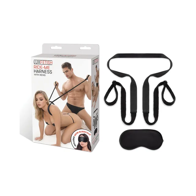 Black Lux Fetish Ride-Me harness with reins and padded panel beside retail box