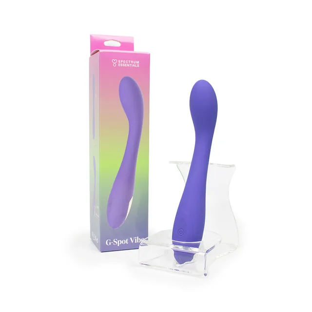 Spectrum Essentials purple rechargeable G-spot vibrator displayed beside its gradient retail box and clear stand