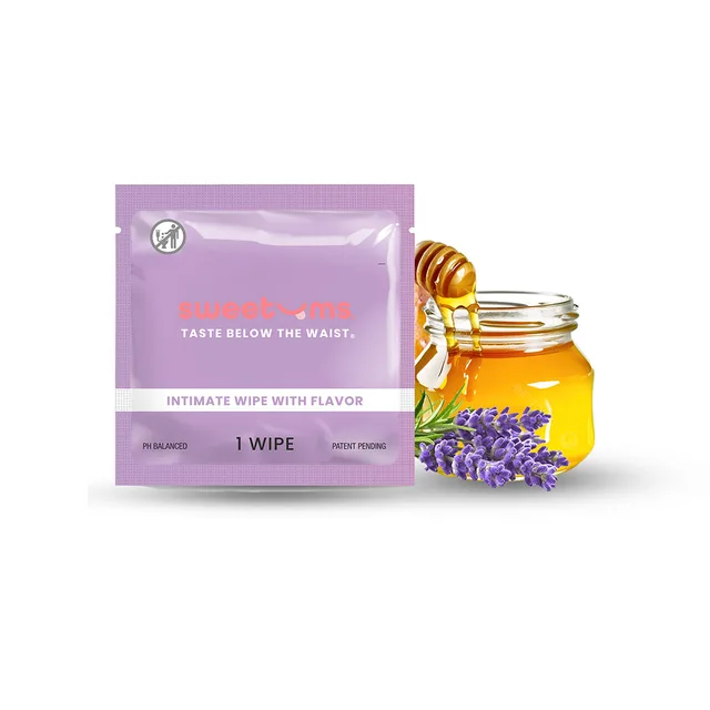 Purple Sweetums Honey Lavender wipe packet beside honey jar and lavender sprigs