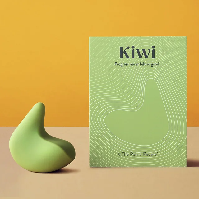 OhNut Kiwi green personal massager beside upright box on mustard backdrop