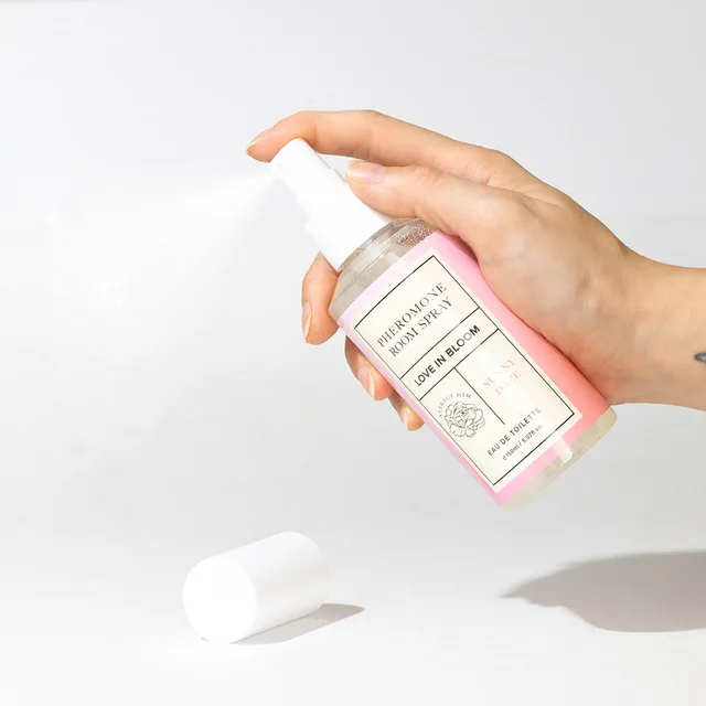 hand pressing the white pump on a light pink Sunny Daze room spray bottle
