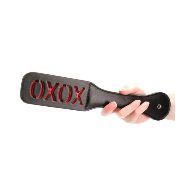Black Ouch paddle with red XOXO lettering and rounded handle