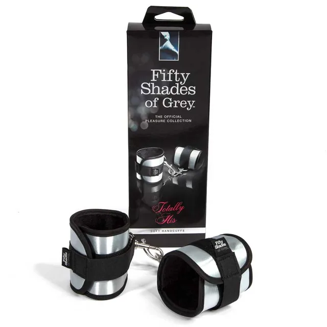 Fifty Shades Totally His Cuffs silver and black cuffs beside tall retail box