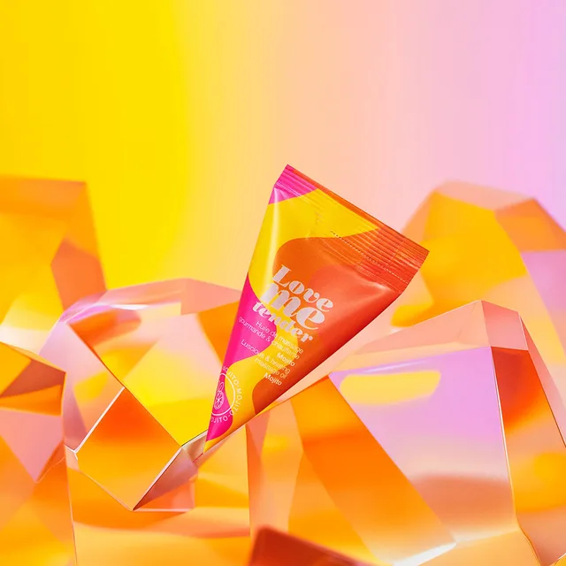 Love to Love Mojito massage oil sachet angled packet among orange geometric shapes
