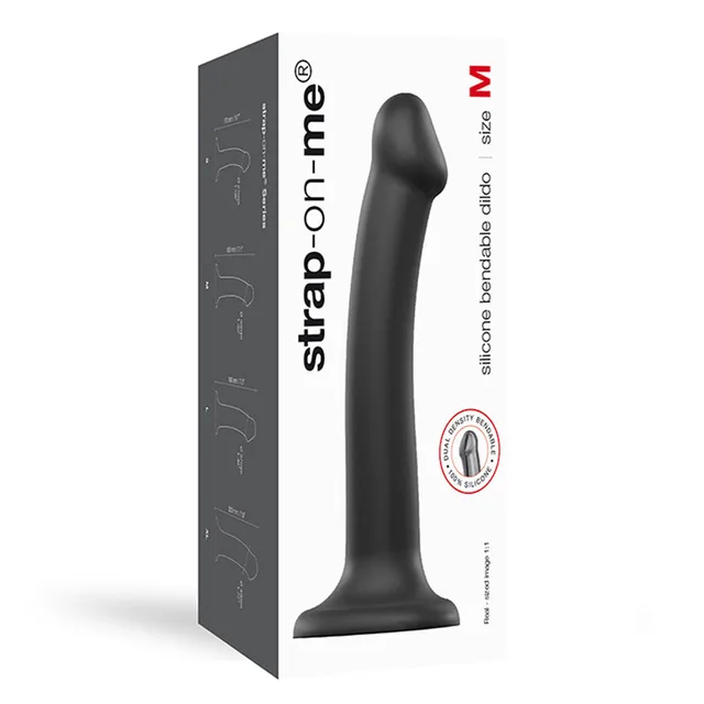 Black medium Strap-On-Me silicone dildo beside tall white package