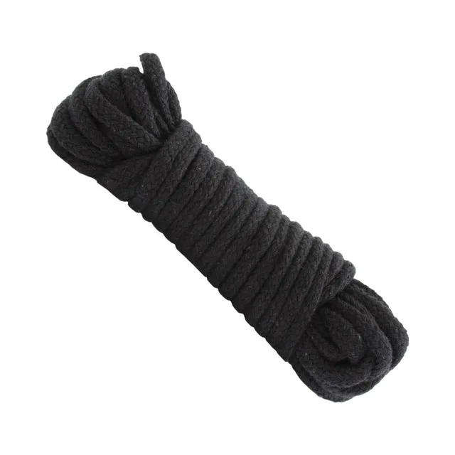 Thick black cotton bondage rope arranged in a coiled bundle