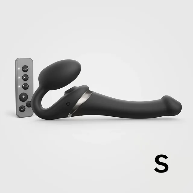 small black Strap-On-Me Multi Orgasm strapless strap-on beside handheld remote