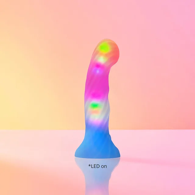 Lovely Planet Candy Loop LED silicone dildo pink-and-blue curved dildo illuminated on a pastel surface