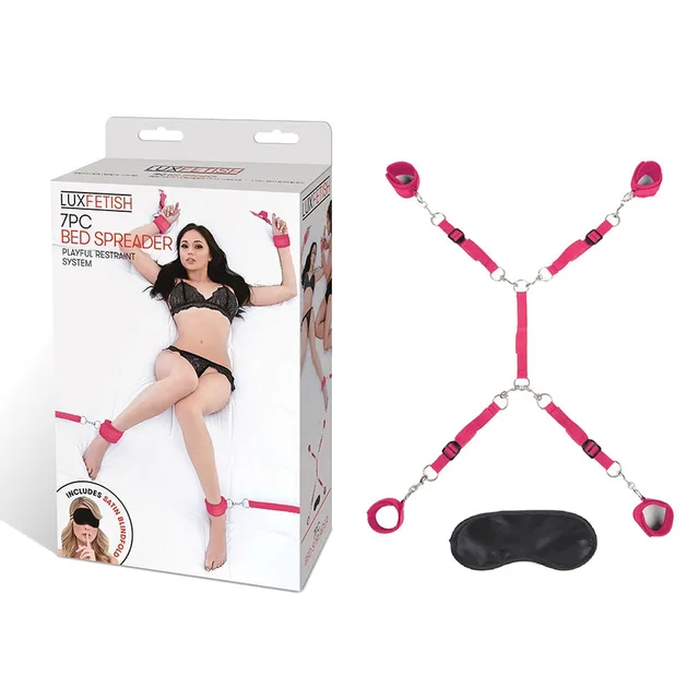 Hot pink bed restraint straps and black mask beside retail box