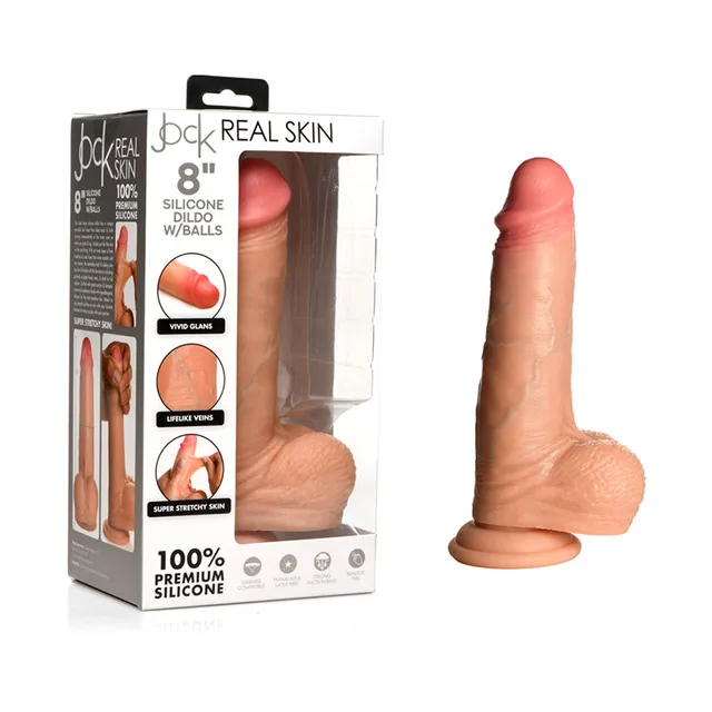 light-tone Jock Real Skin silicone dildo with balls and suction base beside windowed box