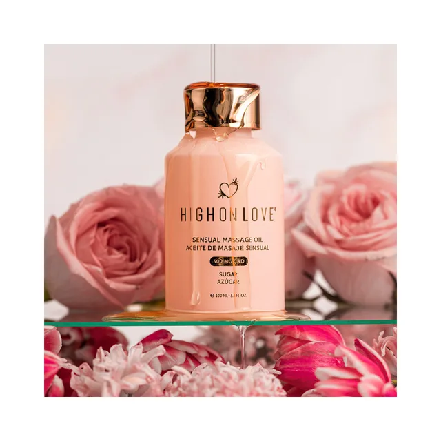 HighOnLove Sugar High CBD massage oil bottle arranged among pink roses