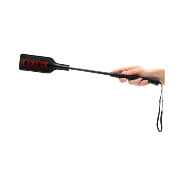 Black Ouch crop with XOXO paddle held by the wrapped handle