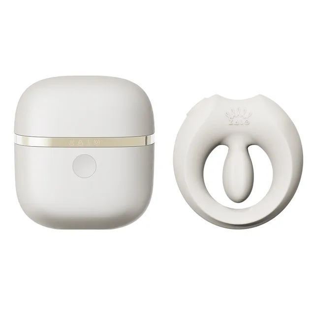 Zalo Legend Apis Ivory White wearable ring vibrator set ring beside the rounded gold-trimmed charging case