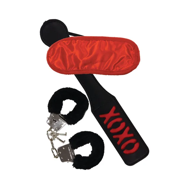 black faux-fur cuffs red blindfold and XOXO paddle arranged together