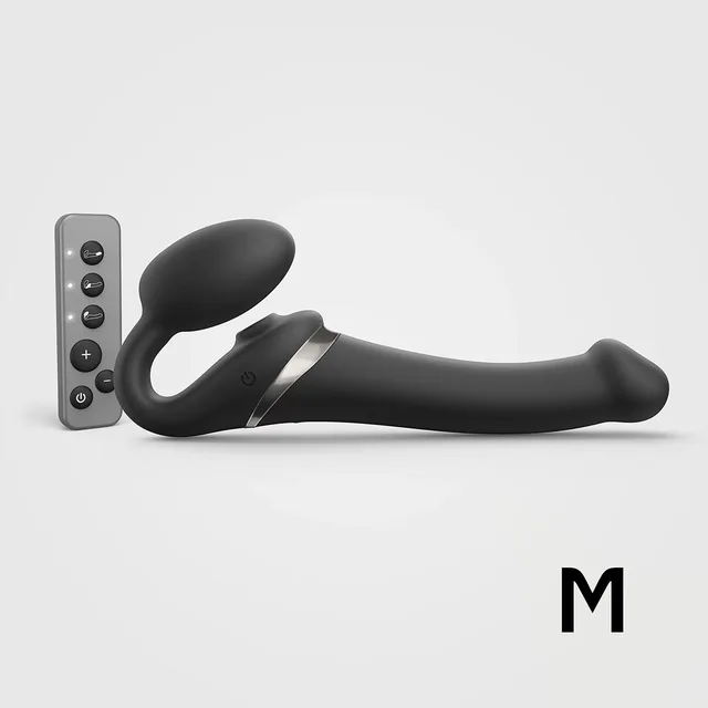 medium black Strap-On-Me Multi Orgasm strapless strap-on beside handheld remote
