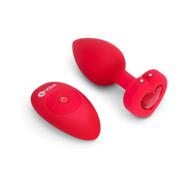 Red b-Vibe Heart plug beside oval remote control