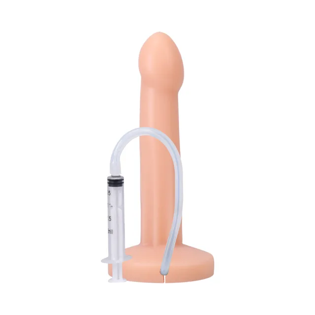 Cream POP dildo beside connected graduated syringe