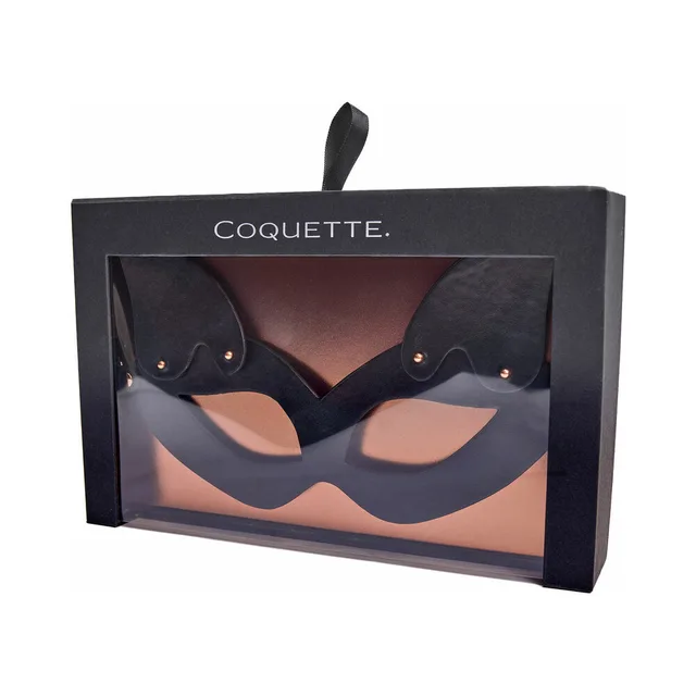 Coquette black cat-ear eye mask visible through retail box window