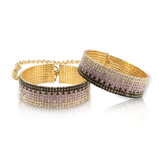 pair of gold-tone bracelet handcuffs with rows of clear purple and dark stones