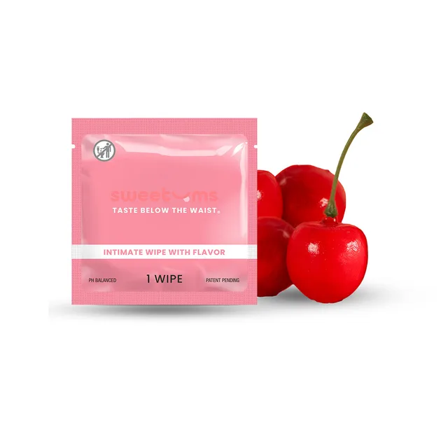 Pink Sweetums Cherry individual wipe packet displayed beside red cherries