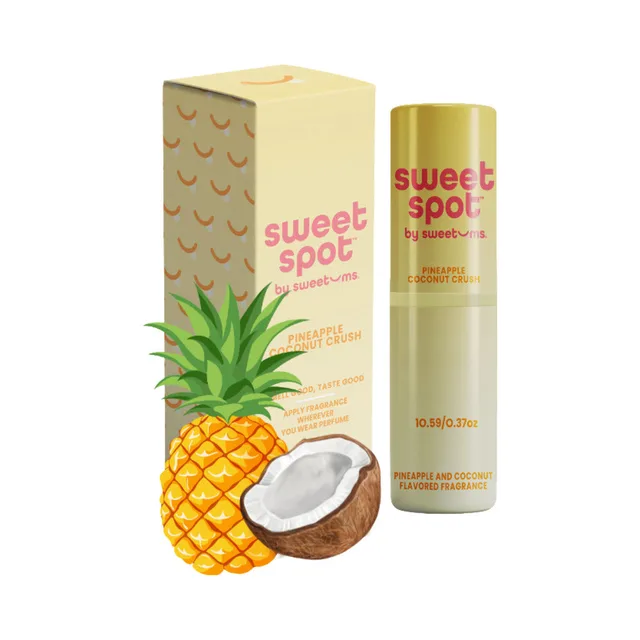 Sweetums Sweet Spot pineapple coconut crush flavored fragrance tube and box arranged with pineapple and coconut halves