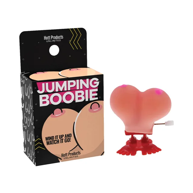 Pink Jumping Boobie wind-up toy with red feet beside black box