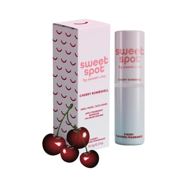 Sweetums Sweet Spot cherry bombshell flavored fragrance tube and box arranged with red cherries