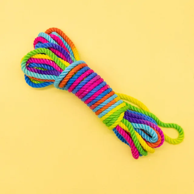 coiled rainbow bamboo-silk rope with multicolor strands on yellow background
