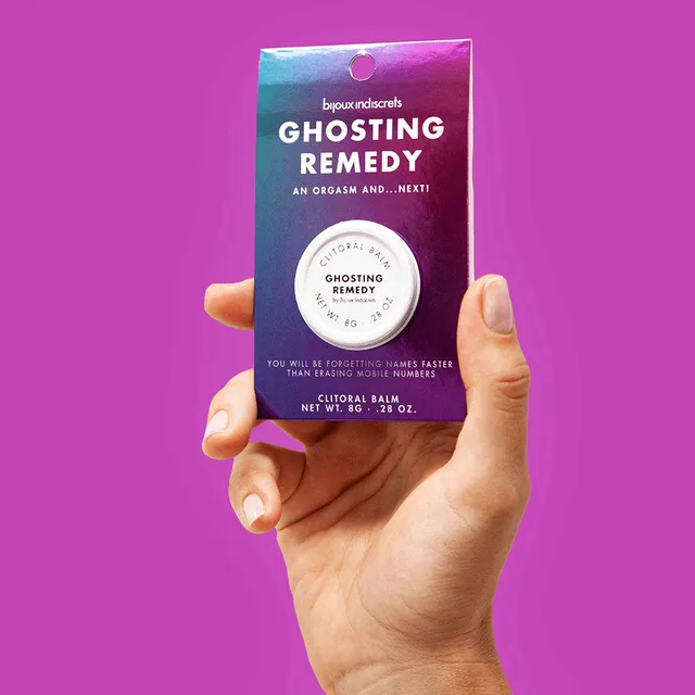 hand holding packaged Ghosting Remedy balm against a magenta background