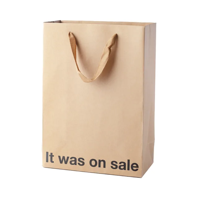 tan kraft gift bag with brown ribbon handles and black printed phrase