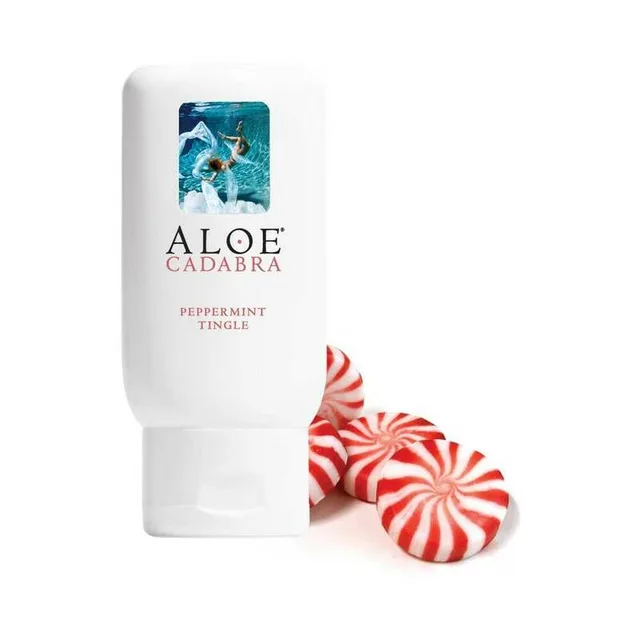 white Aloe Cadabra Peppermint lubricant bottle beside red and white mint candies