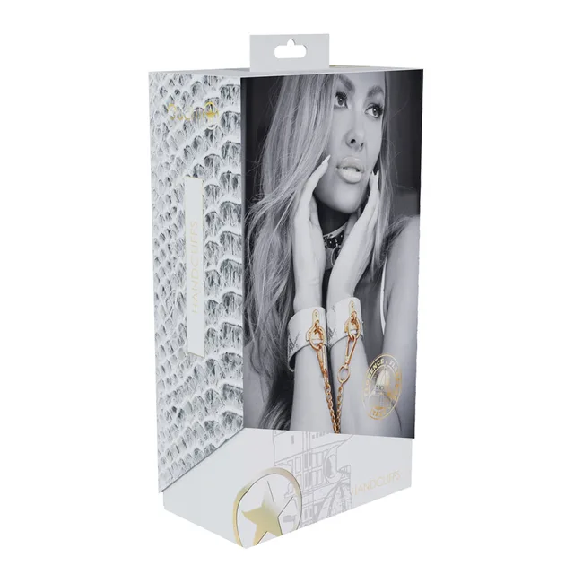 white and silver snakeskin Florence handcuffs with gold chain on box