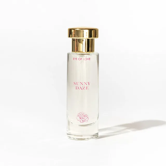 single Sunny Daze glass parfum bottle with gold cap casting a shadow on white