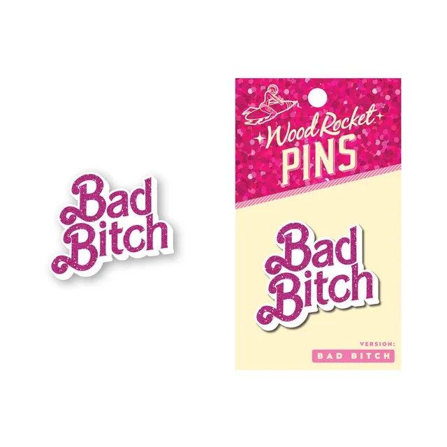 pink Wood Rocket Bad Bitch script enamel pin beside its matching backing card