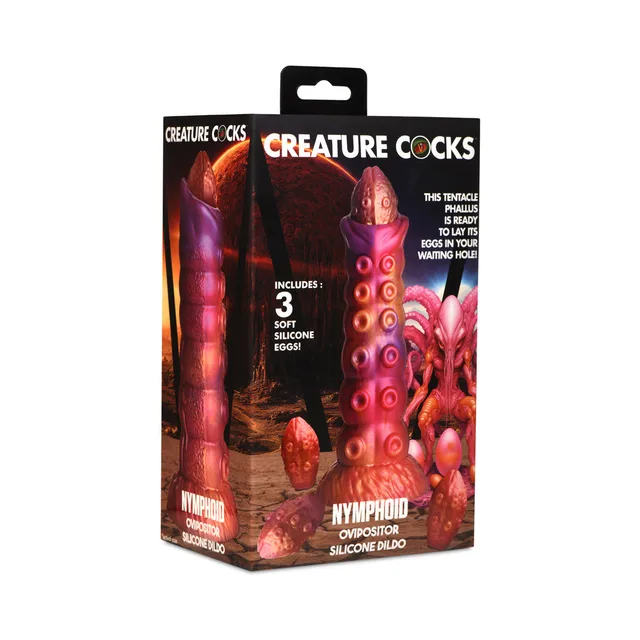 Creature Cocks Nymphoid sunset-color ovipositor with segmented shaft beside illustrated retail box