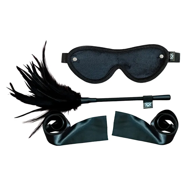 Black satin ribbons, padded blindfold and long feather tickler arranged together