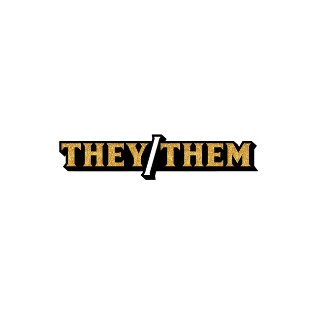 Close view of black They Them enamel pin with gold lettering