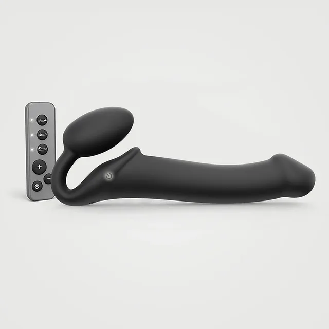 Black large vibrating strap-on beside handheld remote