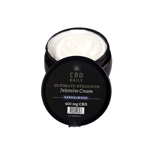 Open black jar of white CBD Daily Sandalwood cream beside lid