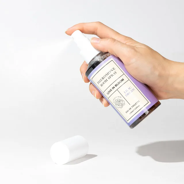 hand pressing the white pump on a pale purple Lilac Dream room spray bottle