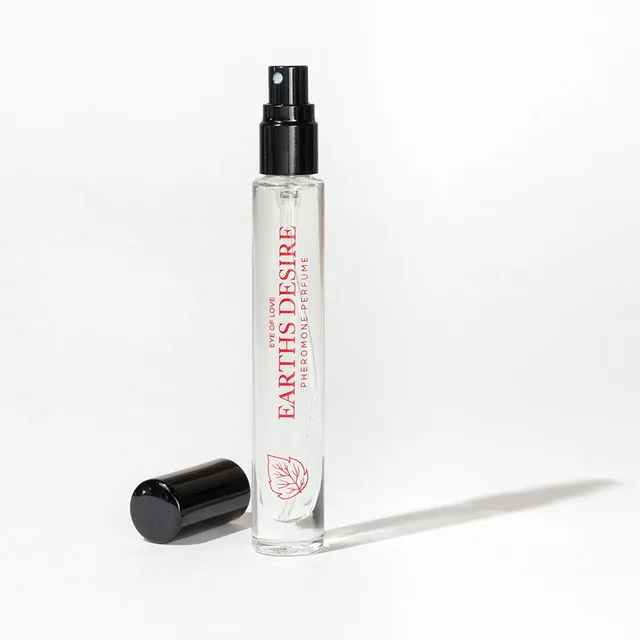 uncapped Earth’s Desire slim spray vial with black cap resting beside it