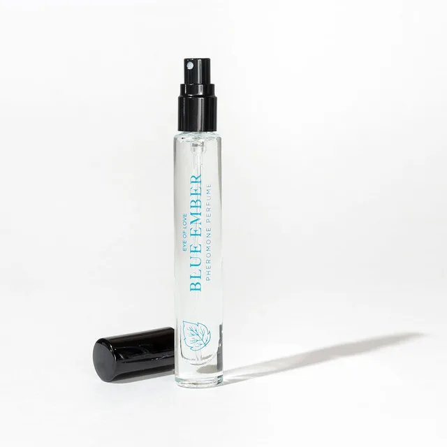 uncapped Blue Ember slim spray vial with black cap resting beside it