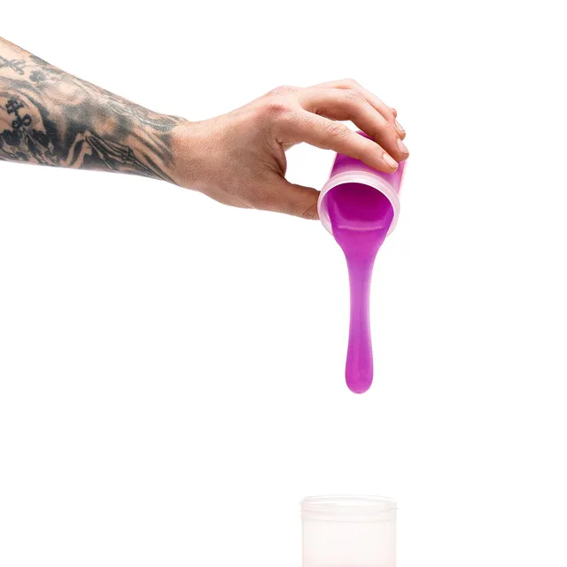 Hand pouring bright purple Clone-A-Willy silicone refill above open container