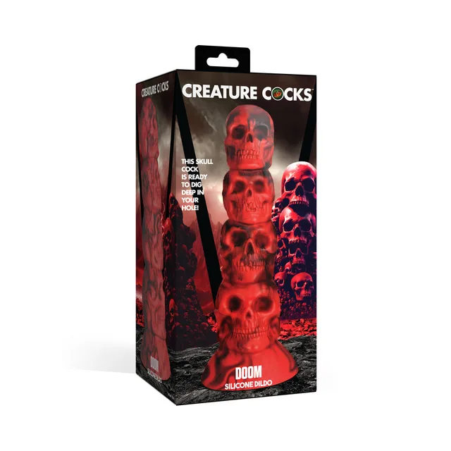 Creature Cocks Doom red stacked-skull dildo beside black-and-red illustrated retail box