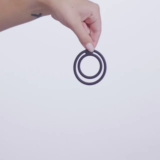 Hand holding the flexible black Nexus Double Enduro linked rings
