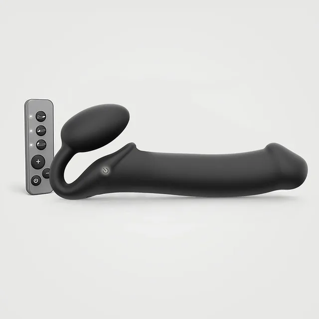 Black bendable Strap-On-Me XL positioned beside its remote