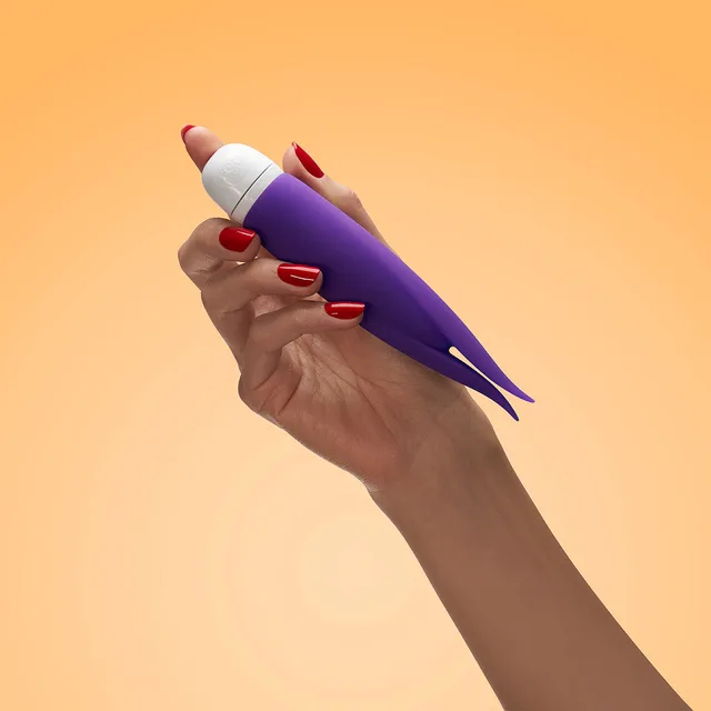 Fun Factory Volita violet twin-tip vibrator held in one hand against peach background