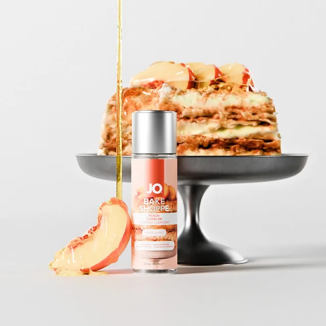System JO peach cobbler water-based lube 2 oz bottle arranged beside peach cobbler desserts