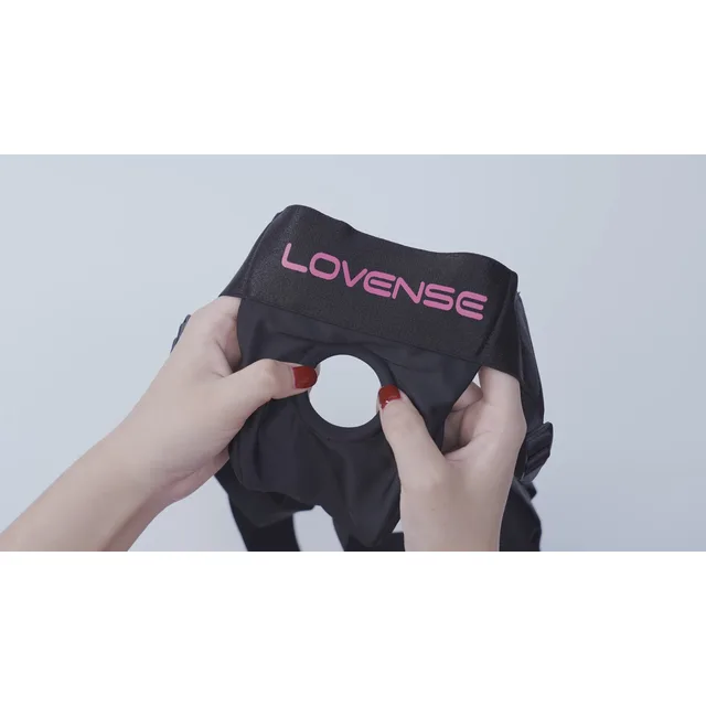 Hands stretching the front ring of Lovense black harness