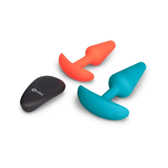 b-Vibe Butties teal and coral training set two plugs and black remote arranged together